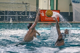 Frederick "Freddy" Schüring beim Wasserball mit pass über einen Verteidiger auf die Centerposition im Angriff